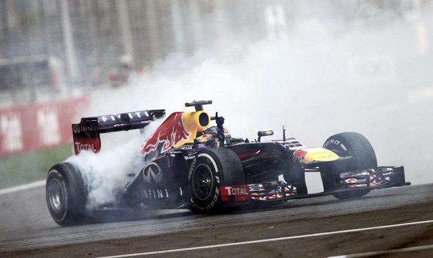 Sebastian Vettel předvádí divákům vítězné kolečko, až se z pneumatik kouří.
