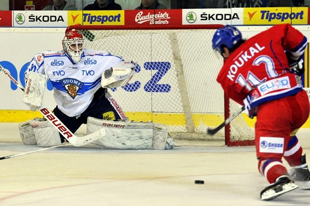Český hokejový útočník Petr Koukal (vpravo) před finským brankářem Jonim Ortiem.
