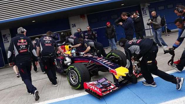 Nechanici tlačí monopost Red Bull mistra světa Sebastiana Vettela do garáže.