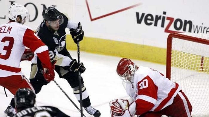 Útočník Pittsburghu Tyler Kennedy překonává brankáře Detroitu Osgooda.