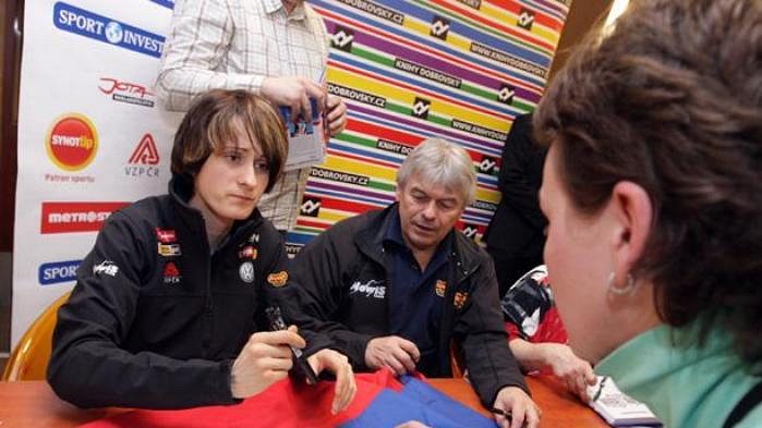 Rychlobruslařka Martina Sáblíková (vlevo) se podepisuje svým fanouškům. Vedle ní sedí její trenér Petr Novák.