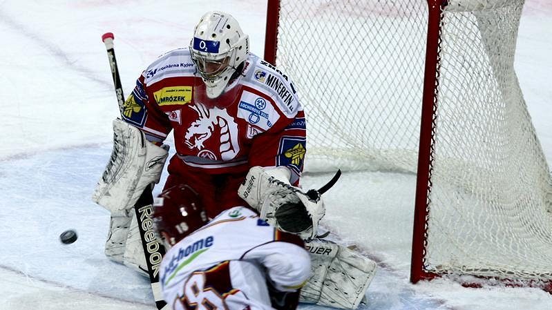 Brankář Třince Peter Hamerlík zasahuje proti střele Ondřeje Kratěny ze Sparty.