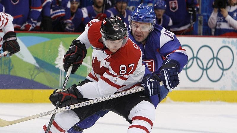 Kanaďan Sidney Crosby si kryje puk před Slovákem Jozefem Stümpelem