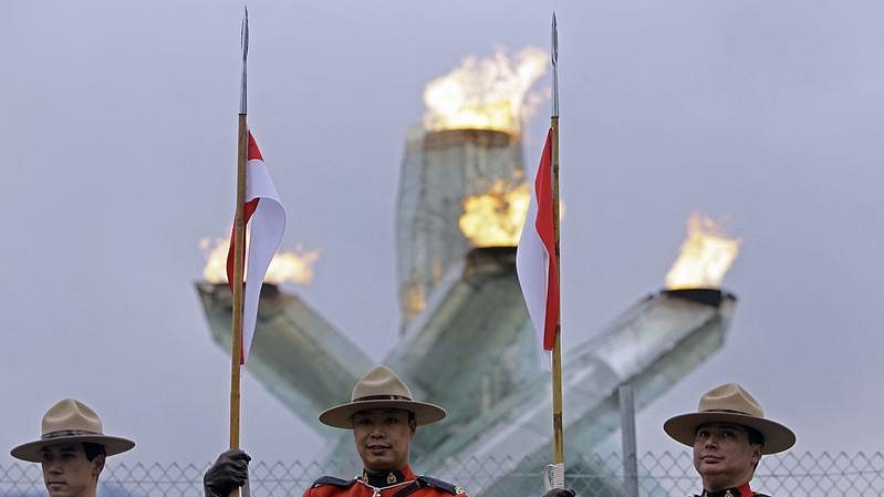 Členové kanadské jízdní policie před olympijským ohněm