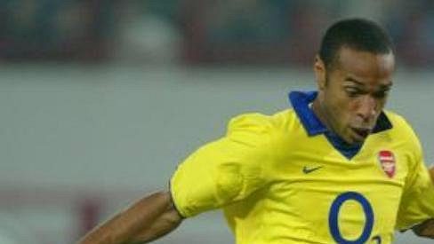 Dmitrij Sennikov z moskevského Lokomotivu (vpravo) se snaží zastavit Thierry Henryho z Arsenalu.