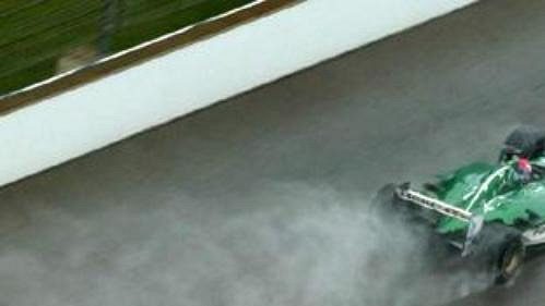 Jaguar Marka Webbera (nahoře) a mclaren Kimiho Räikkönena za sebou nechávají mokrý chvost při průjezdu cílovou rovinkou v Indianapolis.