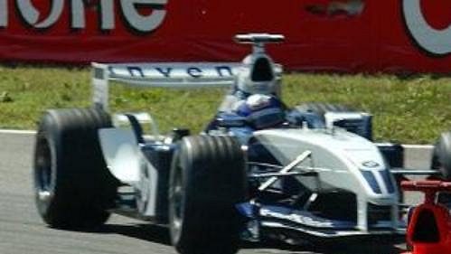 Němec Michael Schumacher ze stáje Ferrari před Kolumbijcem Juanem Pablem Montoyou z Williamsu na trati Velké ceny Itálie v Monze.
