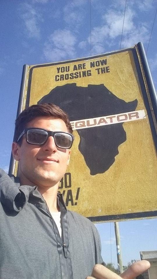 Běžec Jiří Homoláč u cedule značící, že je přímo na rovníku.