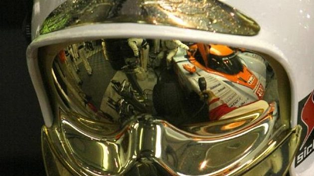 Odraz prototypu Aston Martin posádky Charouz, Enge, Mücke na hledí přilby mechanika v Le Mans.