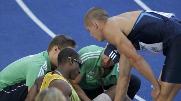 Americký desetibojař Trey Hardee (vpravo) byl po úvodní disciplíně na prvním místě. Pro zraněného Jamajčana Maurice Smitha (vlevo) naopak soutěž skončila.