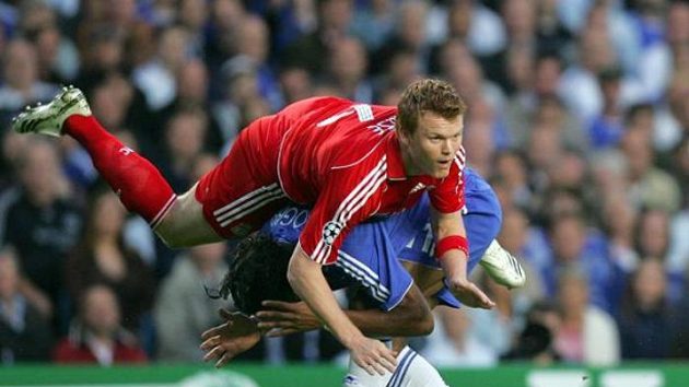 Didier Drogba (v modrém) z Chelsea v souboji s liverpoolským Riisem v semifinále Ligy mistrů.