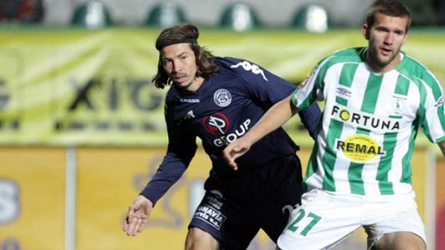 Aleš Urbánek ze Slovácka (vlevo) sleduje jak jebo spoluhráč brankář Petr Vašek kryje míč před Martinem Csehem z Bohemians 1905.