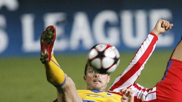Marcin Zewlakow z APOELu Nikósie (vlevo) bojuje o míč s hráčem Atlétika Madrid.