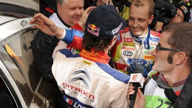 Mikko Hirvonen z týmu Ford (vzadu) gratuluje staronovému mistru světa v rallye Sébastianu Loebovi ze stáje Citroën.