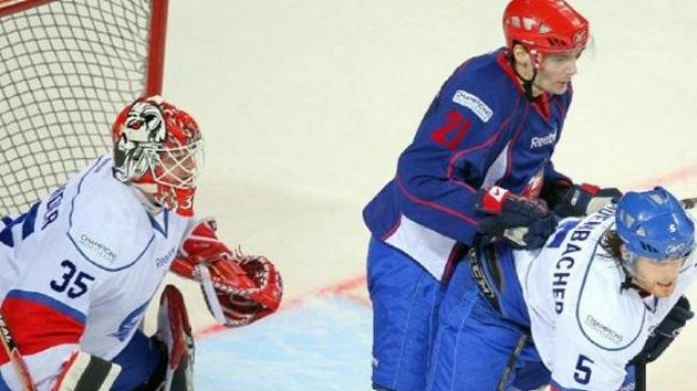 Jaroslav Kudrna z Magnitogorsku mezi brankářem Sulanderem a obráncem Blindenbacherem z Curychu