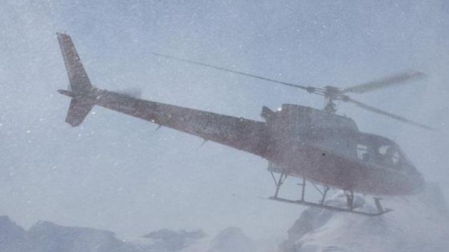 Tomáš Kraus, Michal Novotný, Martin Černík a Robin Kaleta skrytí v oblaku sněhu při výsadku z helikoptéry na vrcholu jednoho vrcholů hor na Aljašce.