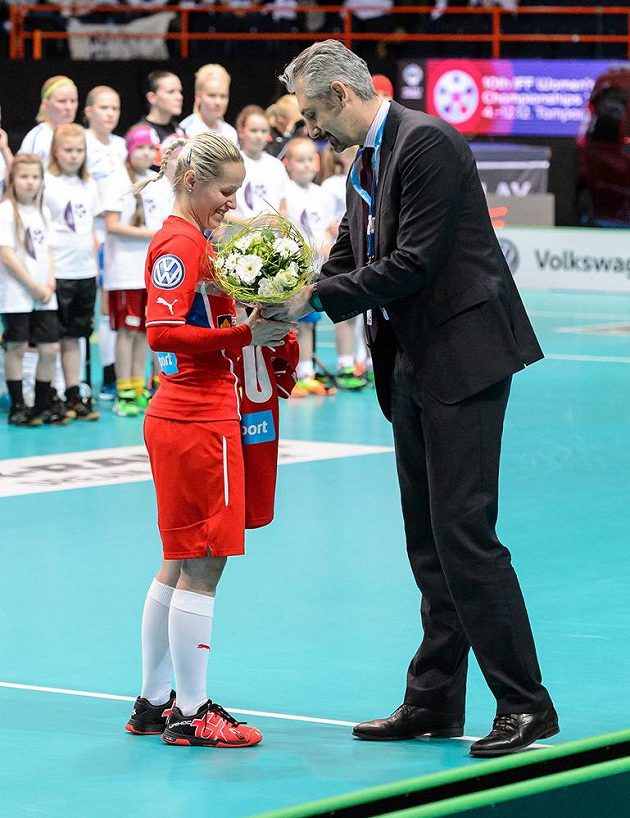 Florbalistka Denisa Billá přebírá od prezidenta Českého florbalu Filipa Šumana kytici a památeční dres připomínající její 100. zápas v národním týmu na MS ve Finsku.