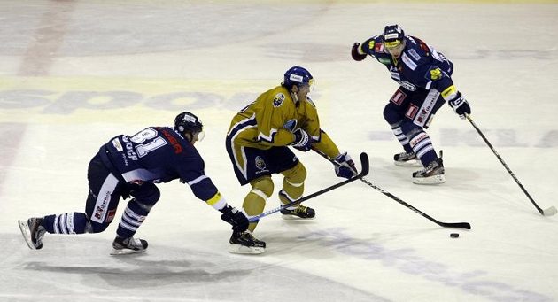 Jaromír Jágr z Kladna (ve zlatém dresu) projíéždí mezi libereckou dvojicí Lukáš Vantuch (vlevo) a Tomáš Pospíšil.