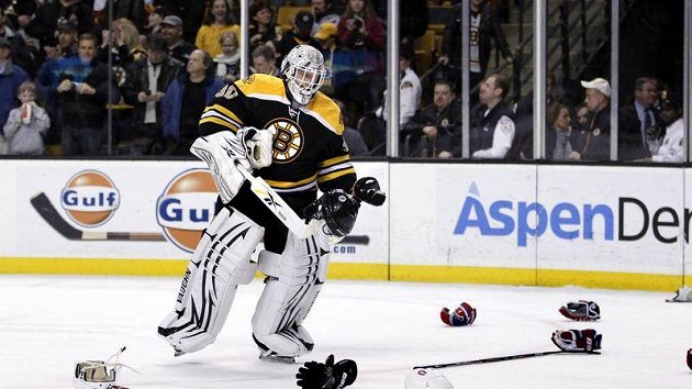 Gólman Bostonu Tim Thomas uklízí spoušť na ledě po jedné z hromadných potyček v duelu s Montrealem.