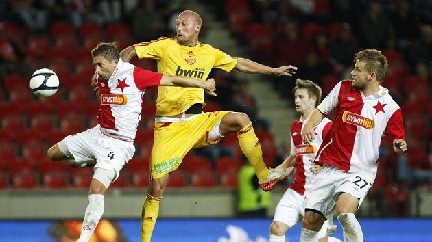 David Hubáček ze Slavie (vlevo) v hlavičkovém souboji s Ivanem Lietavou z Dukly. Vpravo přihlží Zbyněk Pospěch.