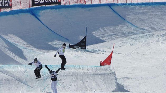 Michal Novotný (vlevo, žlutý dres) vede krátce před cílem svého osmifinále při Světovém poháru snowboardcrossařů ve švýcarské Arose.