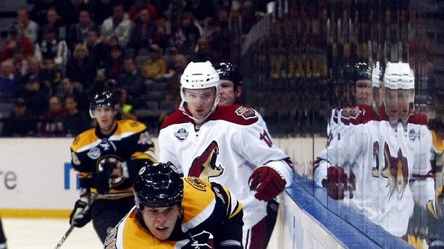 Radim Vrbata z Phoenixu (vzadu) sleduje odjíždějícího Nathana Hortona z Bostonu.