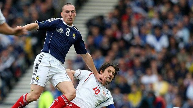 Český kapitán Tomáš Rosický (vpravo) v souboji se skotským protivníkem Scottem Brownem.