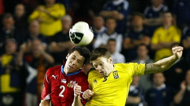 Marek Suchý (vlevo) v hlavičkovém souboji se Skotem Weirem v důležité kvalifikační bitvě v Edenu.