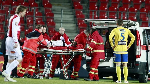 Zdravotníci nakládají přímo na hrací ploše do sanitky útočníka Slavie Riste Naumova.