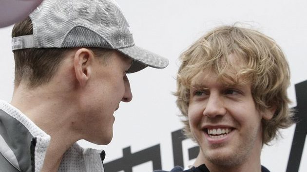 Michael Schumacher při rozhovoru se svým krajanem Sebastianem Vettelem (vpravo), který je pasován do role jeho následníka.