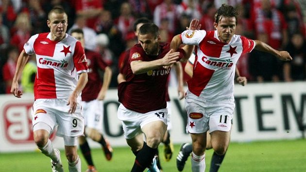 Fotbalisté Slavie Adam Hloušek (vlevo) a Vladimír Šmicer (vpravo) v souboji o míč se sparťanem Janem Holendou v pražském derby