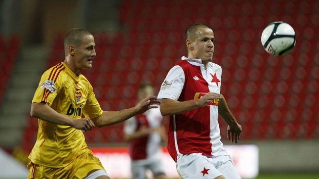Slávista Adam Hloušek (vpravo) se chystá krýt míč před Tomášem Pospíšilem z Dukly Praha