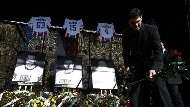 Jaromír Jágr pokládá květinu při pietním aktu na Staroměstském náměstí, kde se lidé lučili se zesnulými hokejisty.