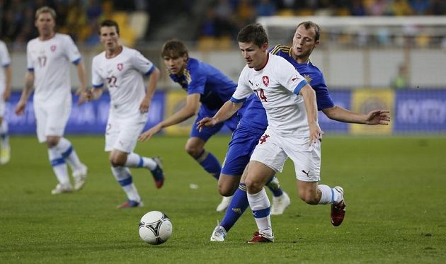 Václav Pilař (v bílém) se snaží udržet míč před dotírajícím soupeřem z Ukrajiny.