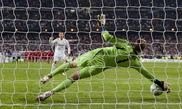 Brankář Bayernu Manuel Neuer chytá penaltu Cristianu Ronaldovi v rozstřelu semifinále Ligy mistrů.