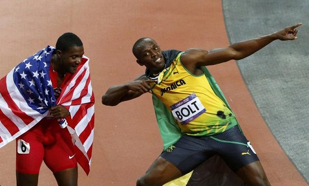 Noví superhrdinové? Usain Bolt (vpravo) a Justin Gatlin opláštění vlajkami Jamajky a USA.