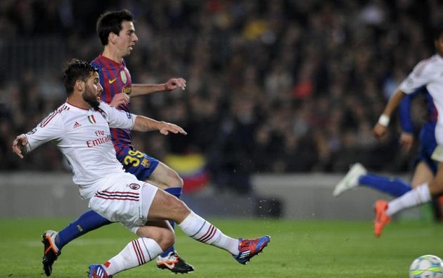 Antonio Nocerino z AC Milán (vlevo) střílí přes Isaaca Cuencaa z Barcelony gól.