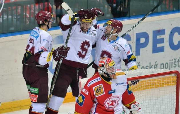 Sparťané zleva Daniel Přibyl, Sacha Treille a Ivan Rachůnek se radují z gólu, vpředu slávistický brankář Domink Furch.