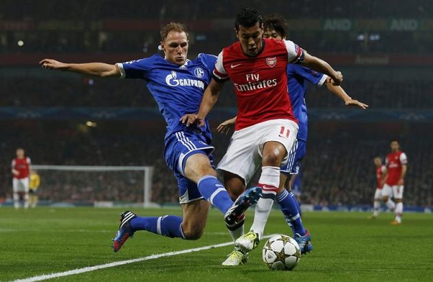 Fotbalista Arsenalu Andre Santos uniká obránci německého Schalke 04 Benediktu Höwedesovi.