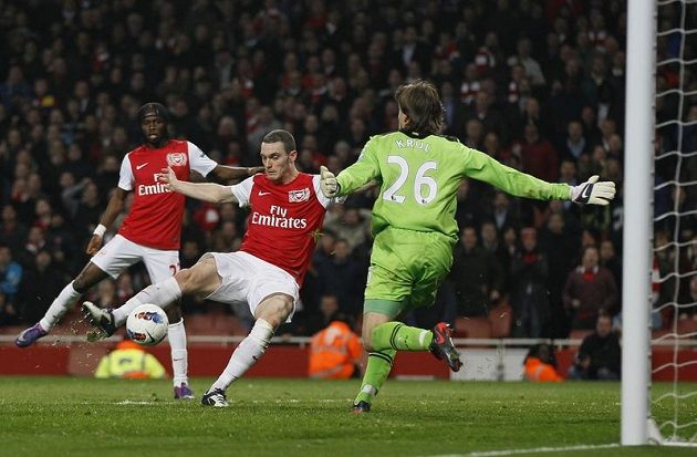 Thomas Vermaelen z Arsenalu (uprostřed) překonává gólmana Newcastlu Tima Krula.