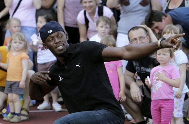 Jamajský sprinter Usain Bolt předvádí dětem v Ostravě své typické vítězné gesto před startem na Zlaté tretře.