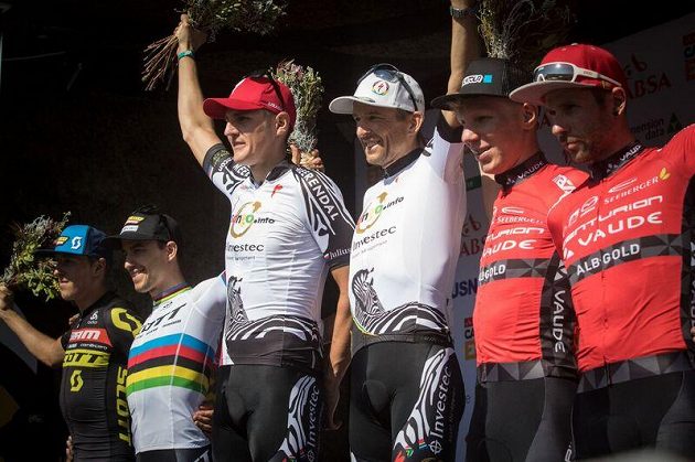 Jaroslav Kulhavý (třetí zleva) a Christopher Sauser (čtvrtý zleva) na nejvyšším stupínku po jednom z etapových triumfů na Cape Epic 2017.