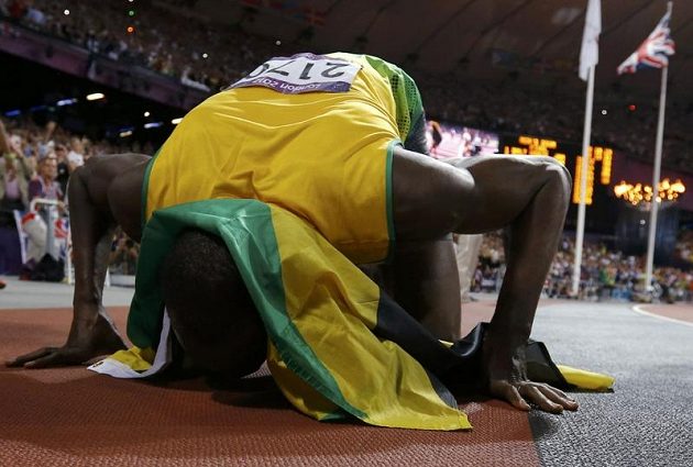 Usain Bolt líbá dráhu na stadiónu v Londýně, kde získal dnes už druhé individuální olympijské zlato