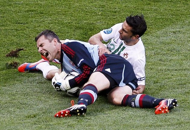 Dánský brankář Stephan Andersen s bolestivou grimasou po srážce se střelcem druhého portugalského gólu Helderem Postigou
