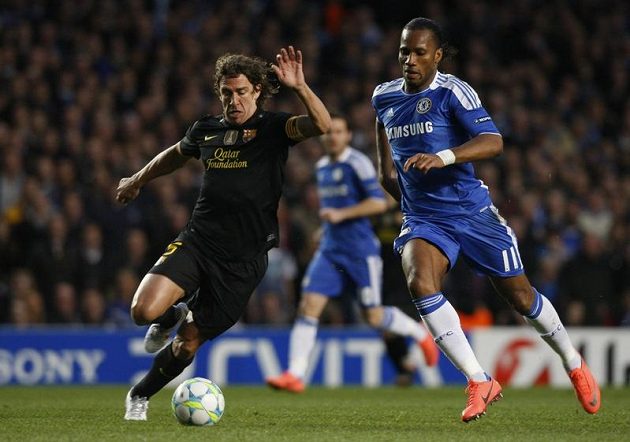 Carles Puyol z Barcelony (vlevo) si kryje míč před útočníkem Chelsea Didierem Drogbou.
