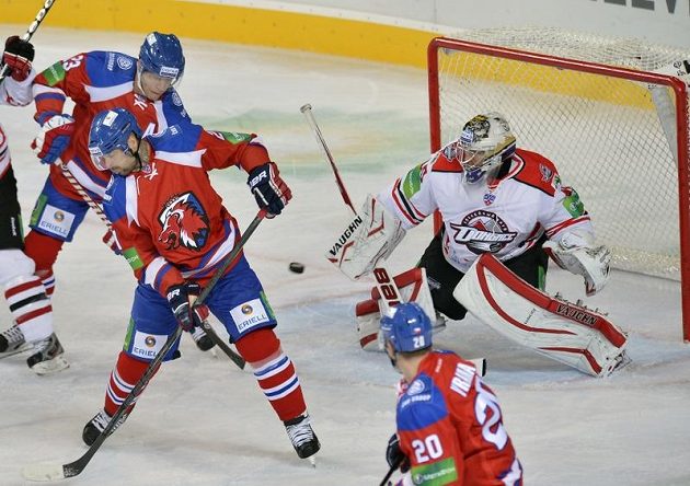 Hráči HC Lev Praha Luboš Bartečko (vlevo), Jakub Klepiš (uprostřed) a Petr Vrána před brankářem Erikem Ersbergem z Doněcku.