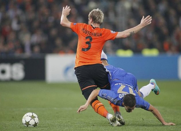 Tomáš Hübschman ze Šachtaru Doněck padá po faulu Edena Hazarda z Chelsea ve třetím kole Ligy mistrů.