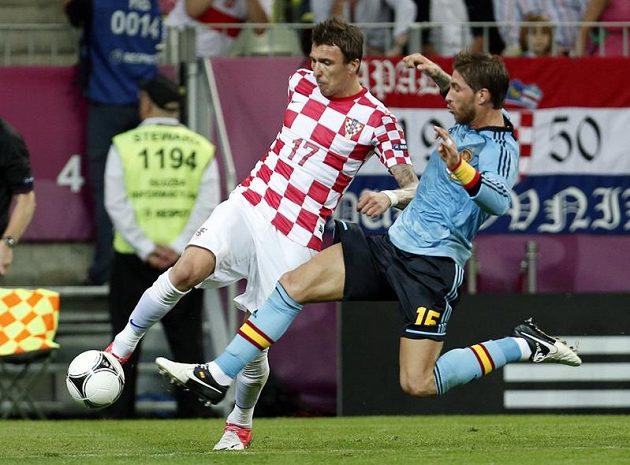 Sergio Ramos ze Španělska (vpravo) skáče do přihrávky Maria Mandžukiče z Chorvatska.