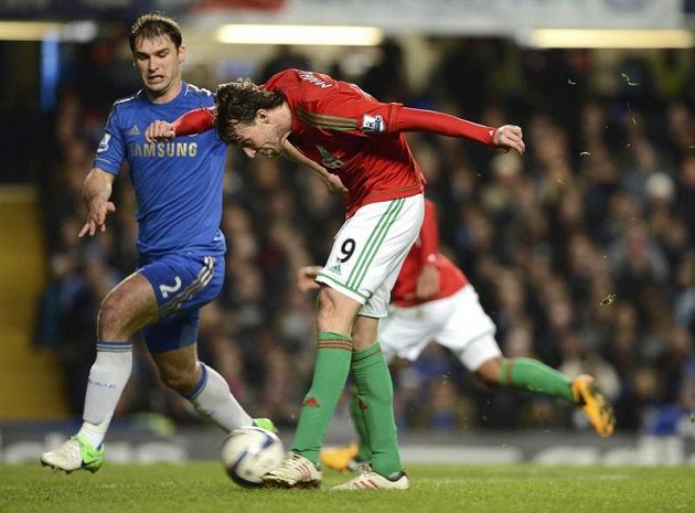 Michu ze Swansea (druhý zleva) se snaží vystřelit na bránu Chelsea v semifinále anglického Ligového poháru. Vlevo přihlíží stoper londýnského klubu Branislav Ivanovič.