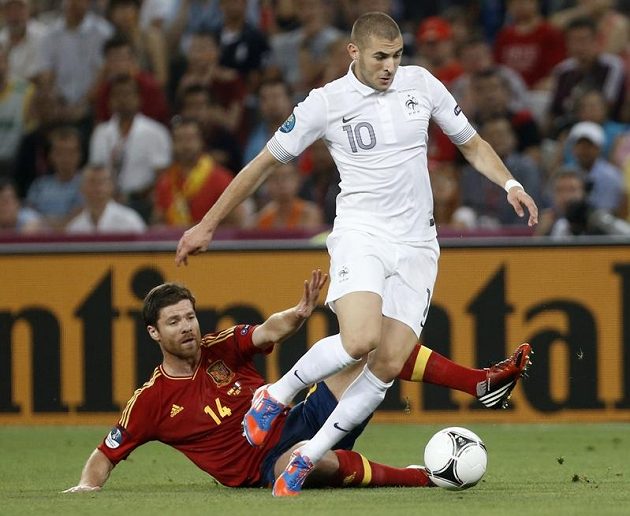 Francouzský snajpr Karim Benzema (č. 10) v souboji se střelcem španělských gólů Xabim Alonsem